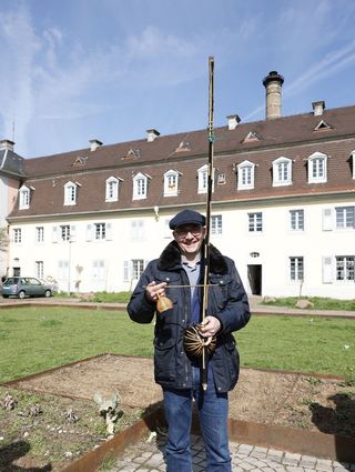 Oberbürgermeister Pöltl probiert das Instrument Berimbau mal aus. Es besteht aus einem Hartholz, einem hohlen Kürbis und einem Draht aus einem Autoreifen.