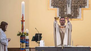 Pfarrer Uwe Lüttinger feiert den Ostergottesdienst in St. Kilian – vor dem Altar steht die neue Kerze für das Kirchenjahr.