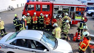 Ausbilder Christian Langlotz (Mitte) erklärt den zukünftigen Feuerwehrleuten während der Grundausbildung, wie bei einem Verkehrsunfall richtig vorgegangen wird.