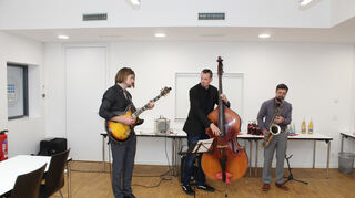 Untermalten die Veranstaltung musikalisch: Kevin Holloway (Gitarre, v.l.), Philipp Wolfart (Kontrabass) und Carl Krämer am Saxophon.