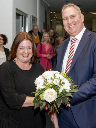 Vorstandsmitglied Achim Seiler überreicht Gerdi König Blumen.