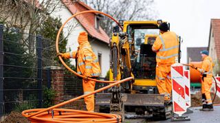 Arbeiter sind mit Bagger und Spaten an einer Straße mit der Erdverlegung von Glasfaserkabeln beschäftigt. In Oftersheim passierte das unter anderem 2018 in der Heidelberger Straße. Nun informieren Mitarbeiter im Auftrag der Telekom über die verfügbaren Geschwindigkeiten.