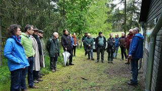 Armin Jendrysik (r.), Projektleiter des Artenschutzprojektes Sandrasen, erläutert den Gästen die neuen Nabu-Banner, die die einzigartige Tier- und Pflanzenwelt in den Sandgebieten beschreiben.