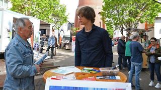Sven Riedner (r.) gibt den Besucher Auskunft über das Projekt „Klimapaten“, das Kommune und Bürger in Sachen Umweltschutz voranbringen soll.