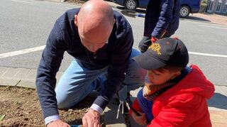 Zusammen mit den Hortkindern bepflanzt Daniel Born die Baumscheiben vor seinem Wahlkreisbüro in Hockenheim.