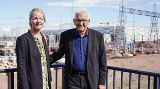 Baden-Württembergs Ministerpräsident Winfried Kretschmann (Bündnis 90/Die Grünen) und die baden-württembergische Umweltministerin Thekla Walker (Bündnis 90/Die Grünen) stehen beim Besuch des ULTRANET-Konverters Philippsburg vor der im Bau befindlichen Anlage.