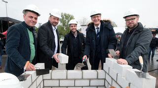 Zeigen ihr Können als Maurer (v l.): Gazmend Wiedmaier vom Pflegedienst, Andreas Metz und Nicolas Zimmermann von „Kalkmann Wohnwerte“, Bürgermeister Dr. Ralf Göck sowie Architekt Michael Rudek.