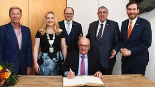 Als neuer Ehrenbürger der Stadt trägt sich Trudbert Orth unter den Augen von Dr. Hans-Peter Wild (v. l.), Bürgermeisterin Patricia Rebmann, Bundestagsabgeordneter Alexander Föhr, Dr. Karl A. Lamers und Landtagsabgeordneter Andreas Sturm ins Goldene Buch der Stadt Eppelheim ein.