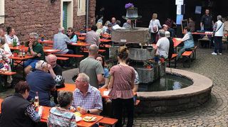 Der Hof ist gut gefüllt: Die Gäste haben es sich an den Biertischgarnituren gemütlich gemacht, es wird geplaudert und gespeist.