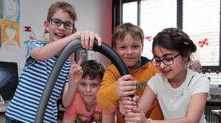Max (v. l.), Elias, Lucas und Azra aus der Kasse 4c präsentieren in der Lußhardtschule als Abschluss der Projektwoche das Experiment „Schokokuss im Vakuum“.