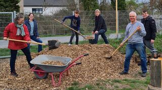 Astrid Trippelt (v. l.), Monika und Jonas Schiefner, Anette Mülbaier, Sandro Schiefner und Stefan Tippelt verteilen eine frische Lieferung Holzhackschnitzel auf dem Gelände des Begegnungsgartens. Sie laden Interessierte zur Mitarbeit ein.