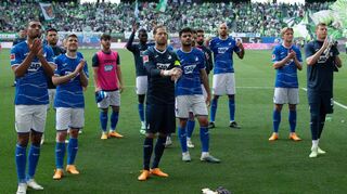 Die Hoffenheimer Mannschaft lässt sich nach dem 1:2 in Wolfsburg von den mitgereisten Fans aufbauen.