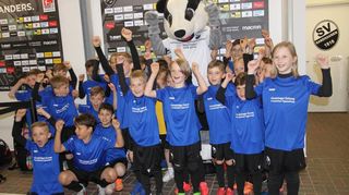 Die Einlaufkinder lassen sich feiern: Ein Bild mit „Hardi“, dem Maskottchen des SV Sandhausen, darf natürlich nicht fehlen. Nach diesem Fototermin heißt es schnell wieder umziehen und zur Tribüne laufen, um den SV Sandhausen kräftig anzufeuern.