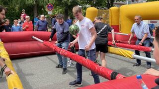 Teilnehmer und Zuschauer des Menschenkicker-Turniers haben gleichermaßen Spaß an diesem außerge-wöhnlichen Spiel.