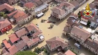 Ein Feuerwehrhubschrauber fliegt über den überfluteten Stadtteil in der Provinz Ravenna. Wegen der teils dramatischen Überschwemmungen gilt in der italienischen Region Emilia-Romagna weiterhin die höchste Alarmstufe rot. (18.5.2023)