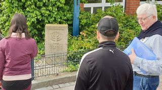 Klaus Brandenburger (rechts) mit zwei Schülern vor dem Gedenkstein zur Deportation nach Gurs am Hockenheimer Rathaus.