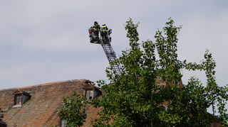 Die Feuerwehr Speyer ist mit Drehleitern vor Ort, um das eingestürzte Dach zu begutachten.