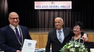 Ende Januar vergangenen Jahres überrascht der Oftersheimer Gemeinderat sein langjähriges Mitglied Roland Seidel (M.) – hier bei seiner Verabschiedung aus dem Gremium mit Ehefrau Gisela und dem damaligen Bürgermeister Jens Geiß – mit der Umbenennung der Kurpfalzhalle. Eine hehre Absicht, die in der Bevölkerung jedoch auf viel Unmut stößt und auf Seidel zurückfällt.