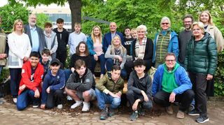Alle beteiligten Schüler, Vertreter der Schulleitung, Elternschaft, Stadtverwaltung, Gäste und beteiligte Unternehmen stellen sich zum Gruppenbild auf, nachdem sie die Werke bewundert haben.