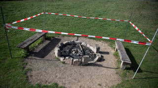Ein Absperrband ist um eine Feuer- und Grillstelle aufgebaut.