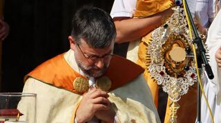 Pfarrer Müller kniet vor dem Allerheiligsten, das für den Leib Jesu steht, und spricht gemeinsam mit den zahlreich erschienenen Gläubigen ein Gebet.