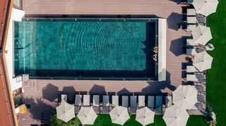 Das macht Lust zum Abtauchen: der Blick auf den Pool mit Liegemöglichkeiten im Walchsee Aktivresort.