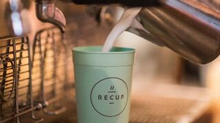 Milch fließt in einen „Recup“-Becher: Die Mehrwegverpackung soll eine Alternative zum Wegwerfprodukt bieten.