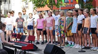Der Chor der Klassen 5a und 5b unter der Leitung von Lehrerin Henriette Basler (l.) erfreut die zahlreichen Geburtstagsgäste des Privatgymnasiums Schwetzingen mit seinen Liedern.