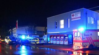 Blaulichtmeer vor der DRK-Rettungswache im Talhaus, auf deren Dach die vom DRK betriebene Unterkunft für wohnungslose Menschen untergebracht ist: Polizei- und Rettungsfahrzeuge stehen nach dem Vorfall vorm Gebäude.