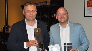 Siegfried Zenker, Bürgermeister von Weinböhla und Oftersheims Rathauschef Pascal Seidel präsentieren die gegenseitigen Geschenke.