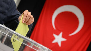 Ein Wähler wirft seinen Wahlumschlag in eine Urne in einem Wahllokal für die türkische Präsidentschaftswahl.