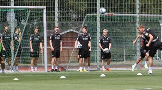 Neuzugang Rouven Henings (r,) zeigt seine Kopfballstärke. Die neuen Teamkollegen schauen beim Trainingsauftakt des SV Sandhausen beeindruckt zu.