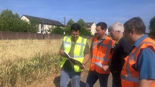 Kai Schemenauer (v. l.), Stefan Halbritter, Matthias Steffan und Marcus Itte schauen sich die Pläne für den künftigen S-Bahn-Haltepunkt an. Im Hintergrund im Bereich der Lärmschutzwand wird ein Bahnsteig entstehen.
