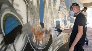 Im Woogbachtal gestalten Maximilian Schneider und Leon Schilling gerade mit ihren Grafitti eine Betonwand.
