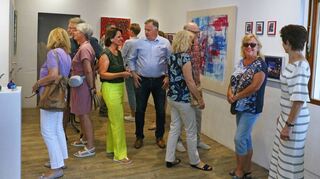 Die hellen Räume bieten einen idealen Rahmen für die farbenfrohen Bilder, die Nicole Fuchs (4. v. l.), hier bei der Vernissage, in „Nic`s Galerie“ ausstellt.