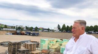 Epple-Pressesprecher Herbert Rabl blickt auf die Baustelle und das Materiallager. Auf der Fläche im Hintergrund wird ein weiterer Abschnitt des neuen Wohnquartiers entstehen.