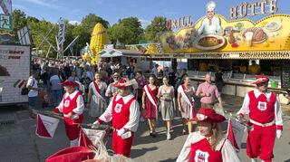 Ein Eröffnungsfestzug mit Schaustellern und Prominenz zieht vom Altpörtel über die Maximilianstraße runter zum Platz und wird angeführt vom Fanfarenzug Rot-Weiß Speyer.