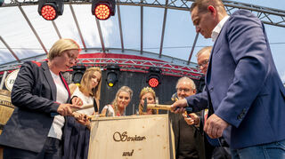 OB Stefanie Seiler (v. l.), die Pfälzische Weinkönigin Lea Baßler, die Brezelkönigin Anne-Susann Sperling, die Rheinhessische Weinkönigin Sarah Schneider, Dr. Armin Schlechter vom Landesbibliothekszentrum, der VVS-Vositzende Uwe Wöhlert und SGD-Präsident Dr. Hannes Kopf beim Zunageln der Weinkiste.