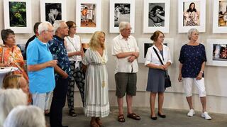 Die Austellung von Volker Jean Rahn wird im Wasserturm eröffnet – die Gäste der Vernissage lauschen den Worten des Künstlers über die Geschichte seiner Fotos.
