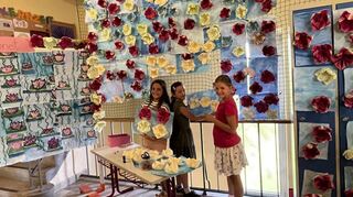 Unzählige bezaubernde Seerosen fertigte die 3a. Anna (v. l.), Luisa und Linda bringen diese an einer Wand an.