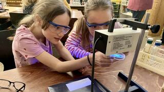 Gut geschützt ans Experimentieren: Die Brille ist Pflicht, als Ella und Franziska mit UV-Lampen Lebensmittel und Alltagsgegenstände zum Leuchten bringen.