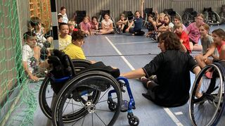 Die Kapitänin der „Rolling Chocolates“ aus Kirchheim bringt den Fünftklässlern Besonderheiten des Rollstuhlbasketballs näher.