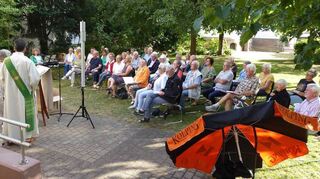 Herrlich im Grünen: Mit Diakon Heiko Wunderling macht der Wortgottesdienst im Pfarrgarten gleich noch mehr Spaß. Gedanklich wurde klar, dass das Entrümpeln nicht nur Last, sondern auch Lust erzeugen kann.