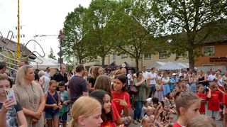 Viele Familien sind gekommen und schauen begeistert ihrem Nachwuchs auf der Bühne zu.