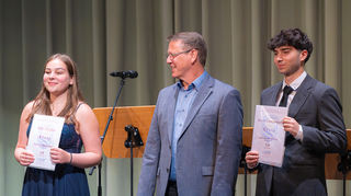 Jule Fischer (l.) und David Thangarajah (r.) erhalten von Bernd Langlotz eine Ehrung für ihre Gesamtleistungen von 1,0.
