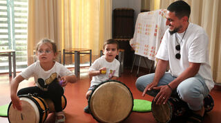 Sie lassen beim Tag der offenen Tür in der Musikschule die Trommeln lautstark erklingen (v. l.): Havva, Musab und Cihan lernen den Kurs Elementare Musik kennen.