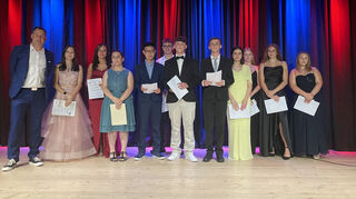 Schulleiter Martin Jendritzki (l.) und die besten Schüler aus den einzelnen Entlassklassen freuen sich über die guten Zeugnisnoten.