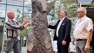 Spürt bei der Arbeit die Kraft aus dem Erdinneren: Künstler Knut Hüneke (v. l.) erläutert Kunstverein-Vorsitzendem Christian Kramberg und Oberbürgermeister-Stellvertreter Fritz Rösch die 2,20 Meter hohe Skulptur „Tanzende Basaltsäule“.