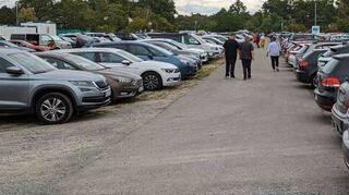 Der Parkplatz P2 in der Nähe des Rings beim DJK Sportplatz ist schon gut gefüllt – im hinteren Bereich auch mit Campingbussen. Die Nummernschilder sind international.