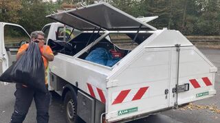 Bauhofmitarbeiterin Renate Brixner wuchtet den Müllsack mit dem Inhalt eines Tages ins Sammelfahrzeug.
